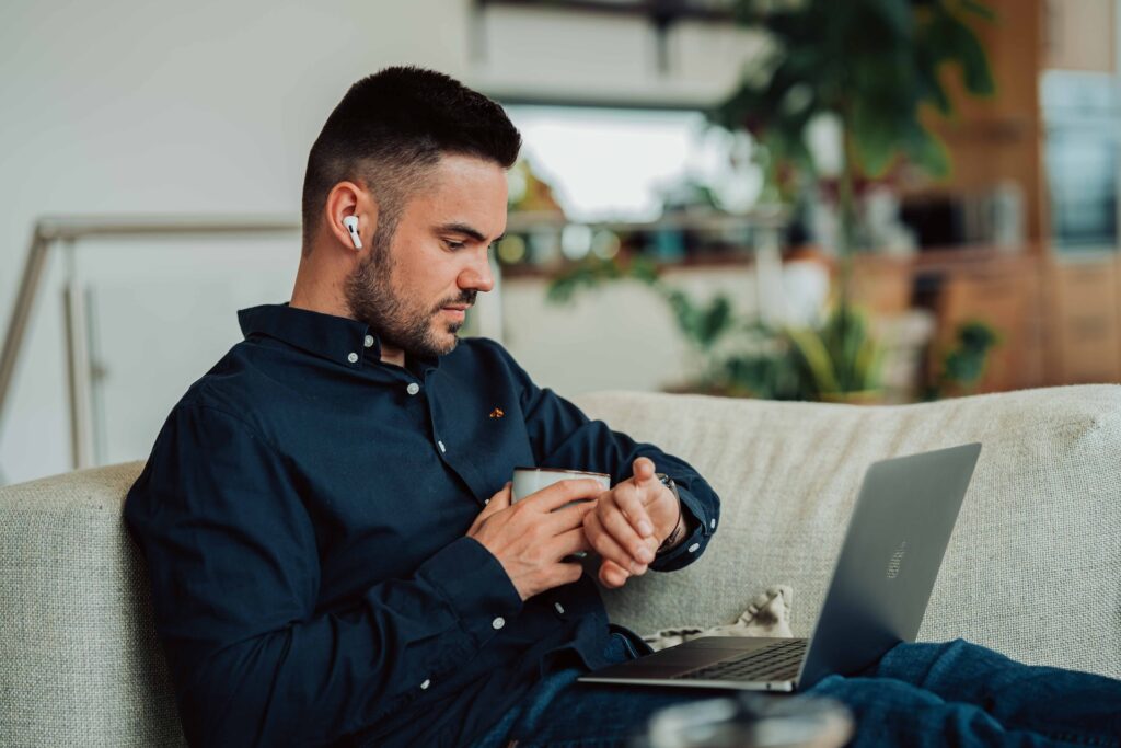 a man drinking coffee in front of his laptop